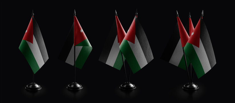Small national flags of the Jordan on a black background