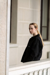 A teenage girl in a black denim jacket turned over her shoulder