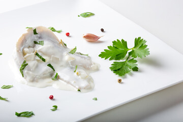 Marinated herring fish in mayonnaise sauce with herbs