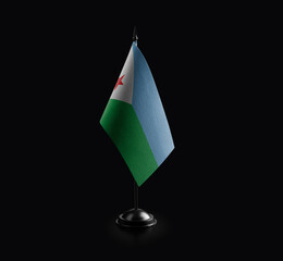 Small national flag of the Djibouti on a black background