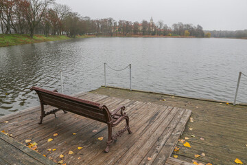 A rest bench stands on the river pier.