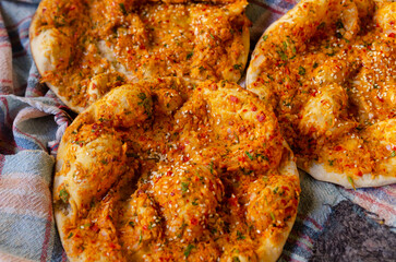 Delicious Turkish Biberli Ekmek “Flat bread with red pepper paste” fresh from cooking in a traditional oven in Antakya Hatay, Turkey