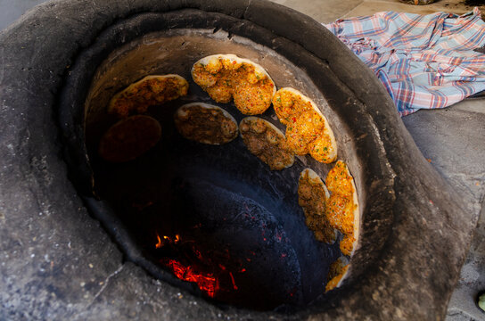 Delicious Turkish Biberli Ekmek &acirc;&euro;&oelig;Flat bread with red pepper paste&acirc;&euro; cooking in a traditional oven in Antakya Hatay, Turkey
