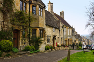 Beautiful stone houses along a quaint street in the Cotswolds village of Burford, England