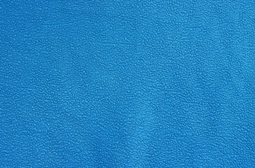 Background of old crumpled blue synthetic fabric.