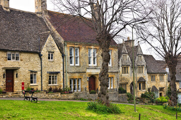 Beautiful stone houses along a quaint street in the Cotswolds village of Burford, England