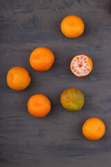 Tangerines (oranges, tangerines, clementines, citrus fruits) on a dark slate, stone or concrete background. Gray background. View from above. Space for text
