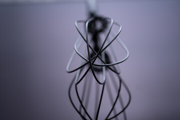 close up of kitchen whisk on dark background with selective focus