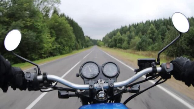 motorbike riding on forest road, first person motorcyclist journey.