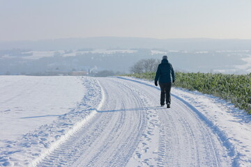 Wanderin läuft im Winter bei Sonnenschein durch das Heckengäu bei Weissach