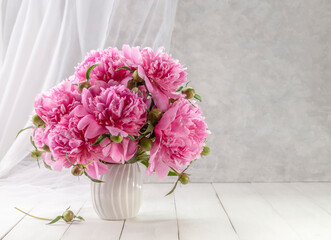 Bouquet of pink peonies in a vase on a wooden table. Gift Valentine's Day