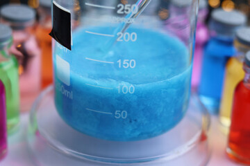 Heavy insoluble particles of blue copper silicate in a beaker.