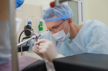 An experienced proctologist examines the patient using special devices for colonoscopy