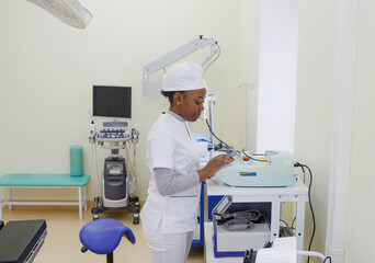 Obraz premium An African-American female doctor sets up an electronic medical device