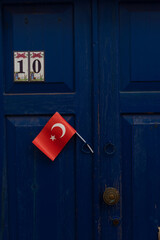 A pretty blue door with a Turkish flag in the charming side streets of the Aegean seaside city of Bodrum, south west Turkey.  .