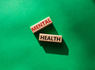 Mental health symbol. Wooden blocks with words Mental health. Beautiful green background. Business and Mental health concept. Copy space.