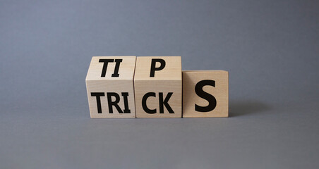 Tips and Tricks symbol. Wooden cubes with words Tricks and Tips. Beautiful grey background. Business and Tips and Tricks concept. Copy space