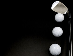 Golf balls and driver on a classic black background