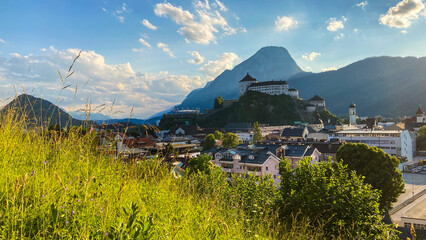 Cityscape of Kufstein, Austria with the Kufstein castle on a hill and the Pendling Mountain in the background.