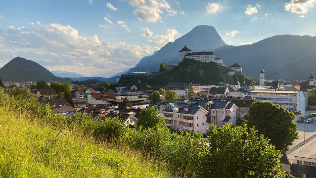 Cityscape of Kufstein, Austria with the Kufstein castle on a hill and the Pendling Mountain in the background.