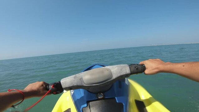 Athletic man rides a jet ski waverunner at sea