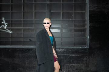 Obraz premium Young and Rebellious Citizen with Short Blonde Hair and Dark Glasses Roams the Back Alleys of Downtown Los Angeles.