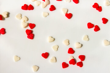 Many small white and red hearts on a white background. The concept of love and romance. Romantic background composition. Valentine's Day