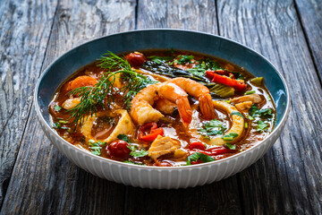 Seafood and fish soup on wooden table
