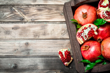 Ripe pomegranates with leaves in the box.