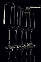 glass goblets outlined with light on a black background
