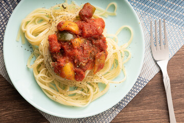 noodles on a blue plate with vegetables