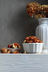 Dried fruits and nuts on a white wooden table.