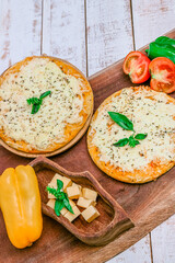 Mozzarella pizzas with albaca. Italian cuisine. White wood background. Ingredients around.