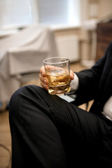 Closeup businessmen holding a glass of whiskey. Man fashion