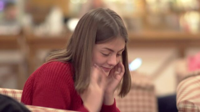 Young confused woman sitting in hotel lobby and looking arround