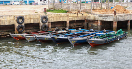 Fototapeta na wymiar Six small wooden fishing boat docking at the pier.