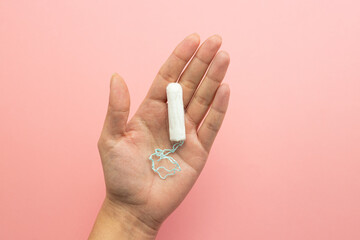 Hand holding a tampon, female menstruation, vaginal bleeding, feminine hygiene