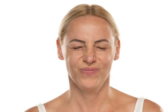 Portrait of a senior woman without make up Close up sour face of a mature blonde woman on a white background.