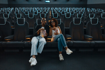 A couple in love watching a movie. Watching a movie in a cinema with popcorn and 3D glasses.