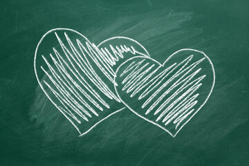 Two hearts are hand drawn with chalk on a greenboard. Valentines day. Love concept.  I Love You