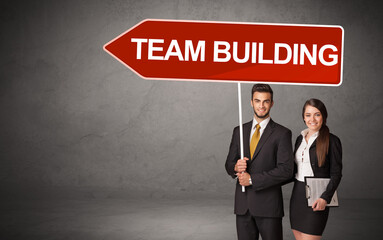 Young business person in casual holding road sign