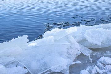 Ice ridges being forced ashore on a river in early winter, daytime, sunny, nobody