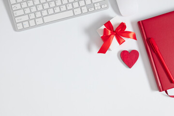 Valentine's Day background. Flat lay, top view office table desk keyboard, red notepad, gift box...
