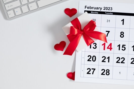 Valentine's Day background. Date February 14 on calendar 2023. office table desk gift box and valentine hearts. Valentines day concept. Flat lay, top view, copy space