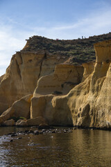 Obraz premium Rocky beach with calm sea on a sunny day.