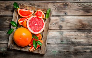 Ripe grapefruit on a wooden tray.