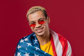 Fototapeta premium Happy man with national USA flag on red background. American patriot, 4th of July - Independence day celebration, election, America, labor. US banner.