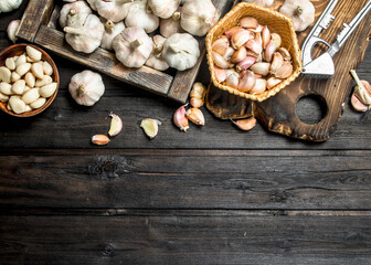 Garlic on a cutting Board with a garlic press.