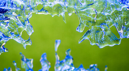 frozen water drops on a green background.blue ice patterns of unusual natural shape.beautiful background with ice silhouettes for ecology medicine cosmetics.