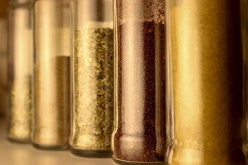 bottles of several spices: thyme, oregano, cumin, black pepper, sumac and chili pepper 
